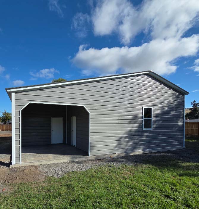Prefabricated American metal barns in a traditional Gambrel style, offering maximum loft storage space and dual sliding doors.