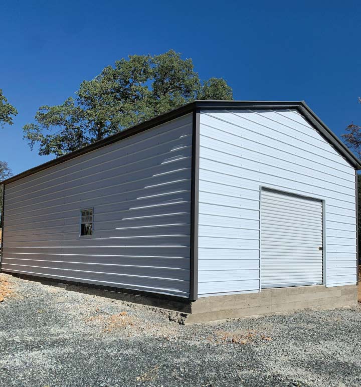 Close-up view of a professional technician securely attaching vertical roof panels during a safe and swift metal garage installation project.